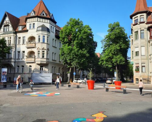 Der Liviaplatz im Leipziger Waldstraßenviertel ist seit Januar 2024 wieder für den Durchgangsverkehr gesperrt. Stattdessen laden Bänke, Pflanzkübel und Spielflächen zum Verweilen ein.
