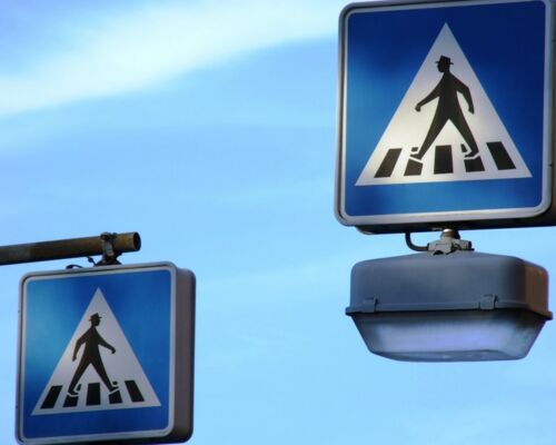 Zebrastreifenverkehrschilder mit Lampe vor blauem Himmel