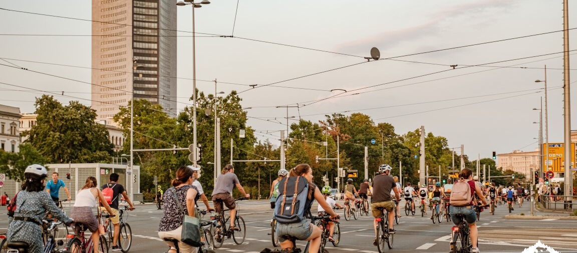 viele Radfahrer auf dem Innenstadtring in Leipzig. Im Hintergrund der Uni-Riese