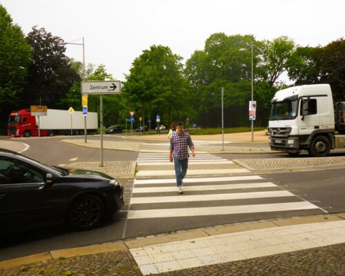 Neue Fußgängerüberwege für den Kreisverkehr in der Karl-Tauchnitz-Straße am Clara-Zetkin-Park in Leipzig werden von Fußgängern benutzt. Autos halten links und rechts, damit Fußgänger sicher queren können.