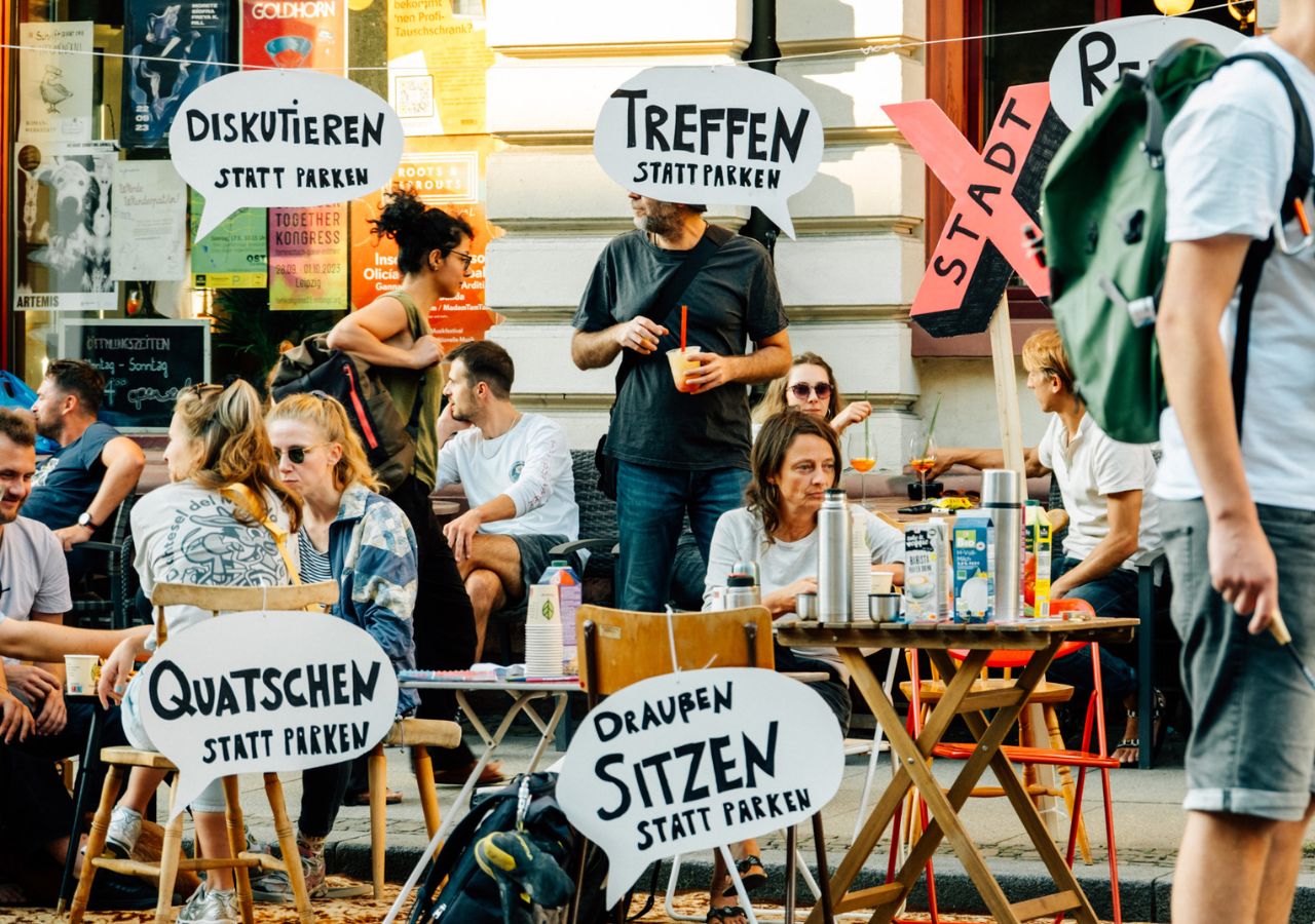 Gemeinsam gestalten Menschen während des Park(ing) Day eine Parklücke zu einem kleinen Park um. Gemeinsam gestalten Menschen während des Park(ing) Day eine Parklücke zu einem kleinen Park um.