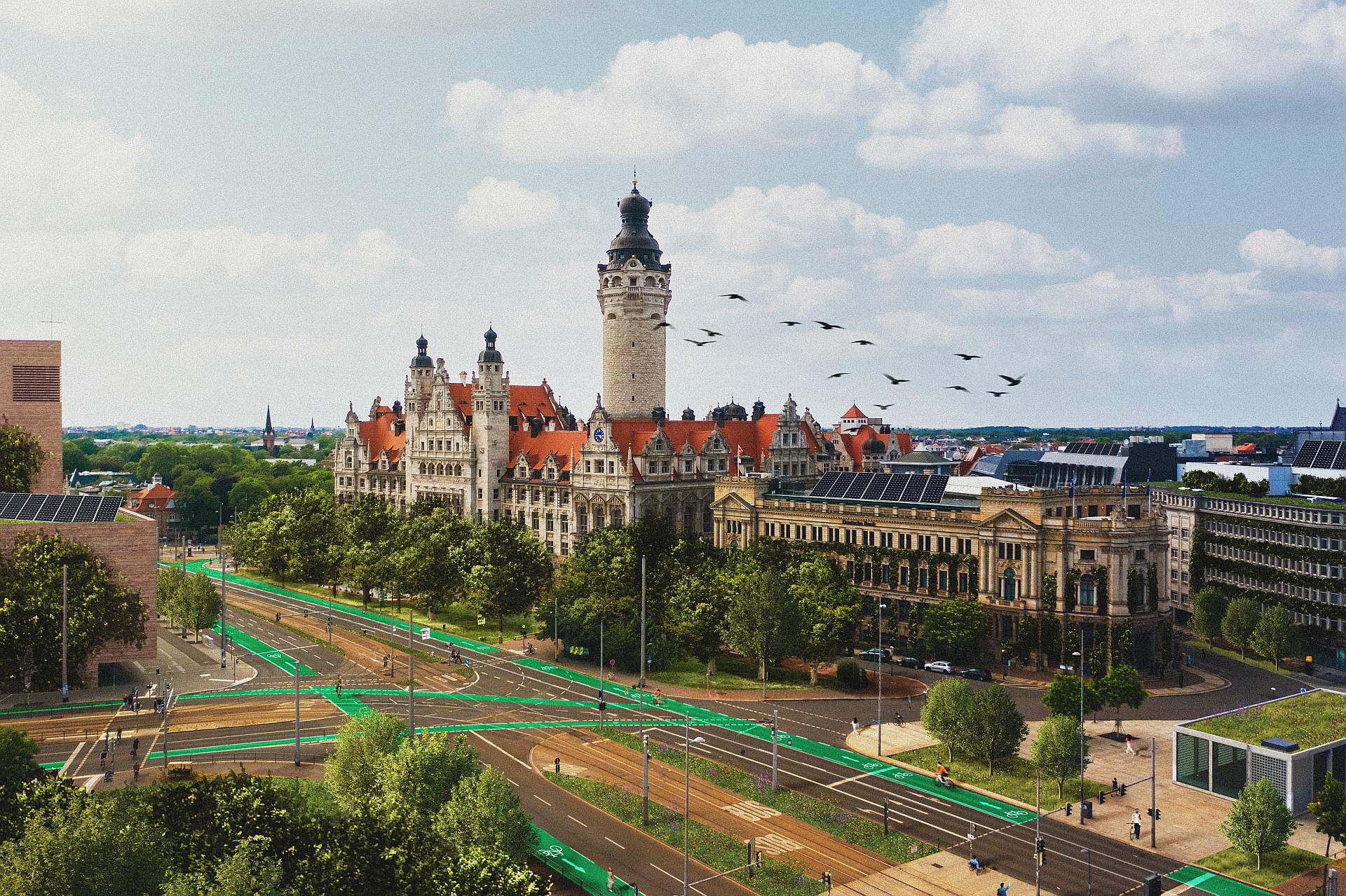 Blick auf das historische Neue Rathaus in Leipzig mit umliegenden Straßen und grünen Radwegen unter blauem Himmel mit Wolken und einer Gruppe fliegender Vögel