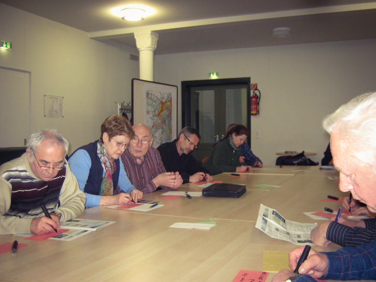 Menschen sitzen an einem Tisch und Schreiben Moderations-Karten