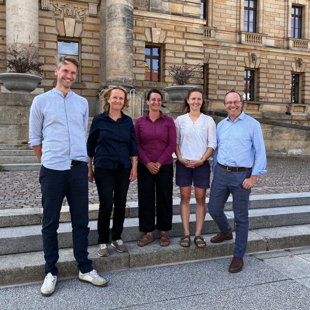Das Bild zeigt Ökolöwen-Geschäftsführer Tino Supplies, Bundesumweltministerin Steffi Lemke, Landtagsabgeordnete Christin Melcher, Ökolöwen-Geschäftsführerin Christiane Heinichen und Landesumweltminister Wolfram Günther auf dem Simsonplatz.