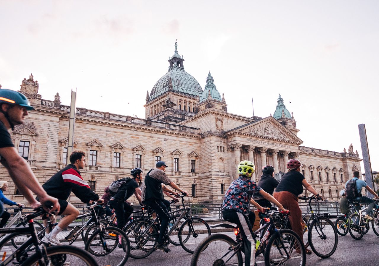 Vor dem Bundesverwaltungsgericht in Leipzig fahren zahlreiche Menschen auf Fahrradädern.